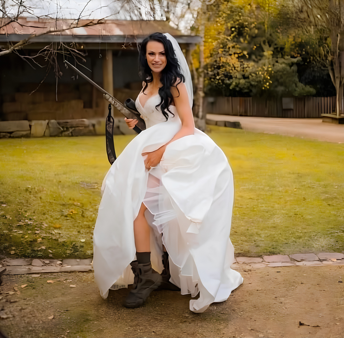 Sharelle Galea in her wedding dress and hunting boots, holding her rifle on the farm