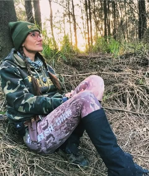 Gaby sitting against a tree in pink camo Ambush leggings at golden hour